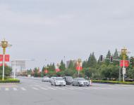 駐馬店市開源大道，道路兩旁清一色的紅旗在迎風(fēng)飄揚(yáng)。所有紅旗都是在燈桿的一側(cè)逆時(shí)針旋轉(zhuǎn)90°豎著懸掛，鮮艷的國旗整齊地朝向一側(cè)，非常壯觀。