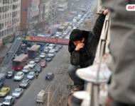 圖為2014年1月3日，蘭州，6名農(nóng)民工為了討薪爬上白銀路一居民樓9樓平臺(tái)要“跳樓”。原來(lái)，該樓4層的甘肅天安建筑機(jī)械工程公司拖欠24名工人的24萬(wàn)元工錢，他們討要5個(gè)月毫無(wú)結(jié)果，便做出危險(xiǎn)之舉。后經(jīng)有關(guān)部門多方協(xié)調(diào)，工人們當(dāng)場(chǎng)拿到了18萬(wàn)元。于永昭/視覺(jué)中國(guó)