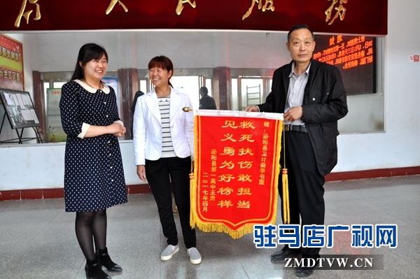 （圖二、縣衛(wèi)計委辦公室主任接過錦旗連聲說好?。?jpg