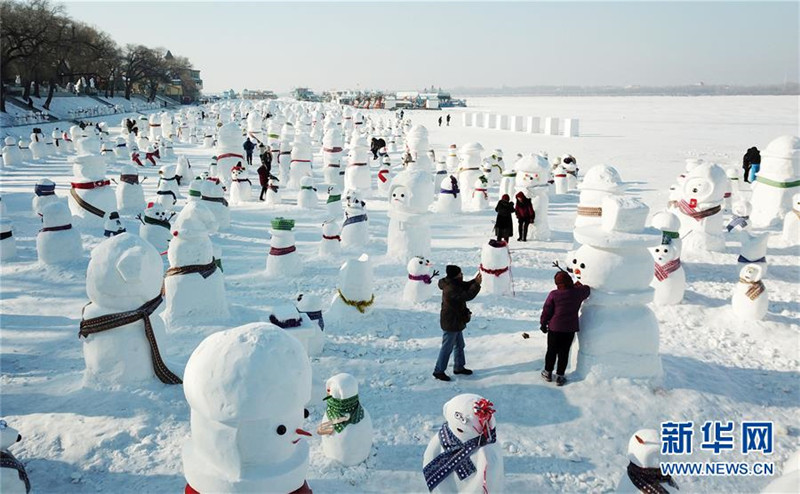 1月2日，市民、游客在雪人群中游玩觀賞（無(wú)人機(jī)拍攝）。2019個(gè)各式各樣的雪人，近日在冰城哈爾濱市的松花江畔亮相，引來(lái)眾多市民游客游玩觀賞。新華社記者 王建威 攝